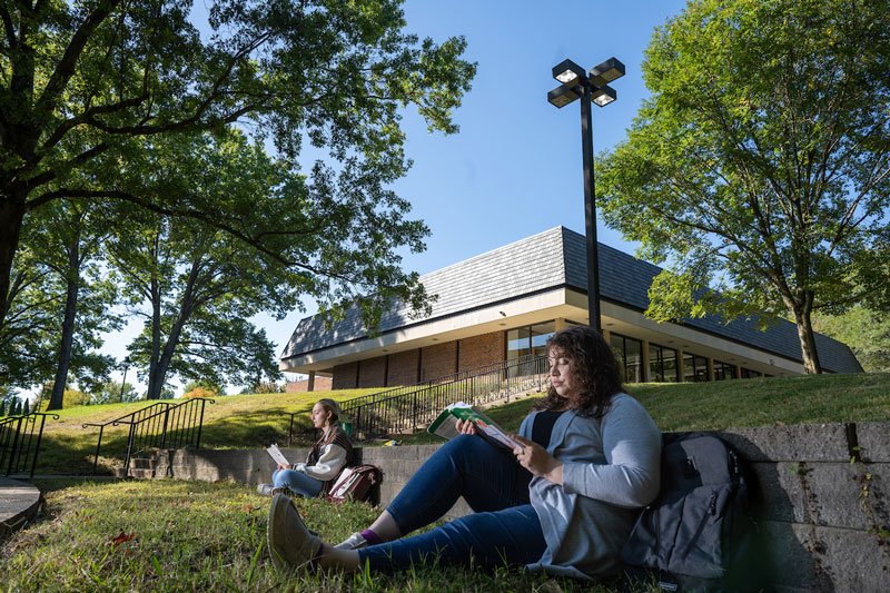 Two students sit in the grass and study outdoors on Ohio University’s Chillicothe campus.