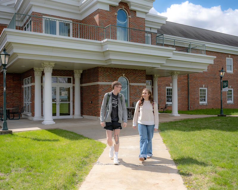Two students walk in front of a brick building on OHIO’s Eastern campus.