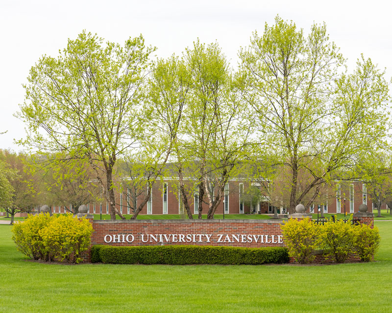 Ohio University Zanesville’s brick entryway, surrounded by trees and other buildings.