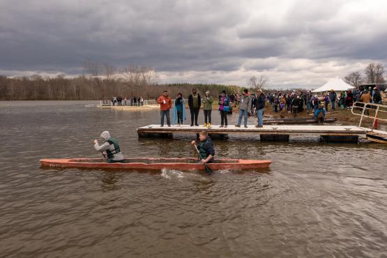 Two Ohio University engineering students paddle in a concrete canoe they built